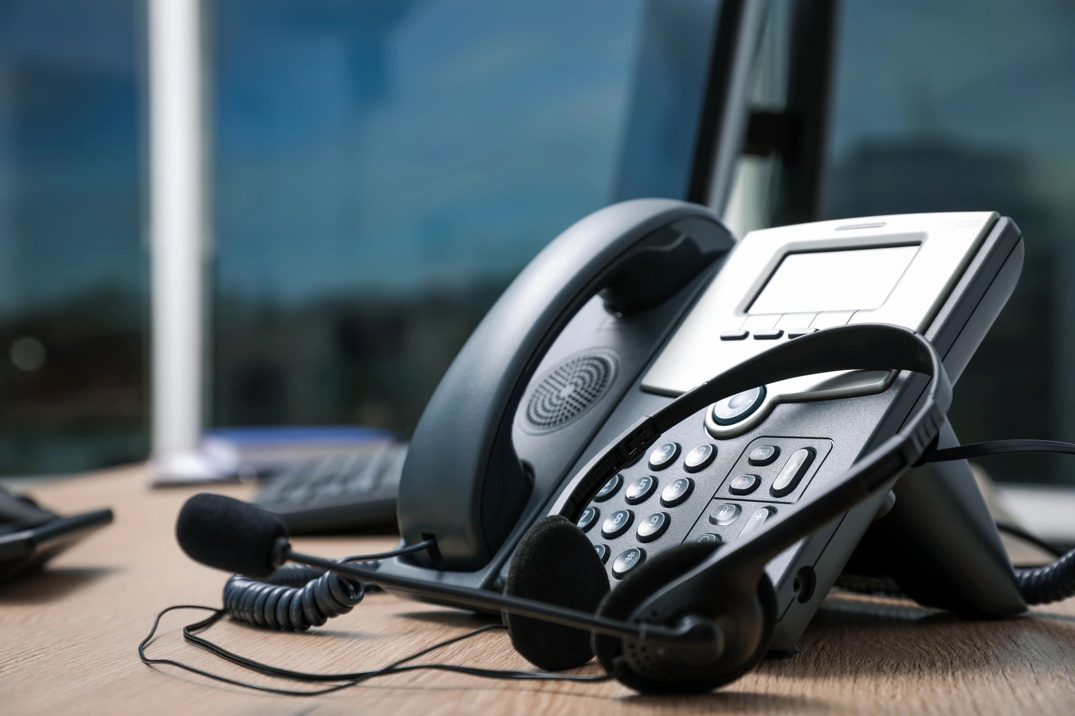 Desk phone and headset on a modern office desk.