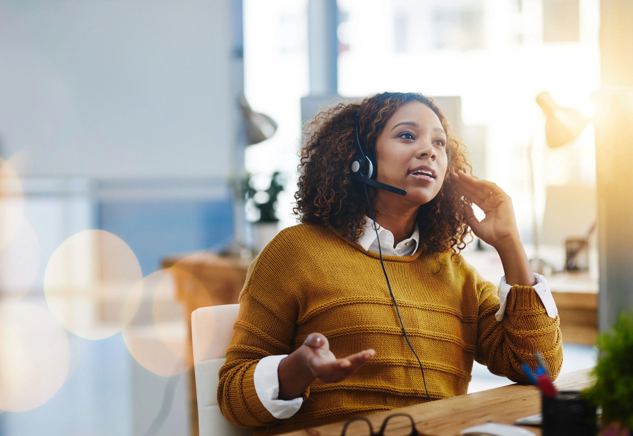 Customer service representative using a phone headset in an office.